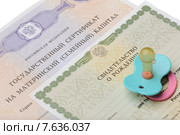 Сертификат на материнский капитал, свидетельство о рождении и детская пустышка на белом фоне. Стоковое фото, фотограф Денис Ларкин / Фотобанк Лори