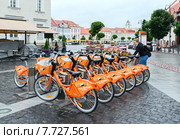 Девушка берёт велосипед в пункте автоматической аренды велосипедов Cyclocity в Старом городе, Вильнюс (2015 год). Редакционное фото, фотограф Ольга Коцюба / Фотобанк Лори