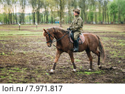Девушка в военной форме едет на лошади (2015 год). Редакционное фото, фотограф g.bruev / Фотобанк Лори