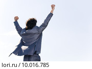 Back of successful businessman in suit raising his hands . Стоковое фото, фотограф Dmitriy Shironosov / PantherMedia / Фотобанк Лори