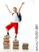 Diligent preschooler standing on the top of book stairs with his arms raised. Стоковое фото, фотограф Dmitriy Shironosov / PantherMedia / Фотобанк Лори
