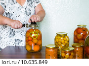 Домохозяйка закатывает банки с домашними заготовками. Стоковое фото, фотограф Володина Ольга / Фотобанк Лори