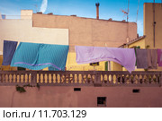 A colorful clothesline in front of an old house and a blue sky in Spain. Стоковое фото, фотограф Rüdiger Wittmann / PantherMedia / Фотобанк Лори
