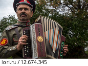 Казак играет на тульской гармони на Пятом международном фестивале "Казачья станица Москва" в музее-усадьбе "Коломенское", Россия (2015 год). Редакционное фото, фотограф Николай Винокуров / Фотобанк Лори