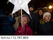 Ребенок держит в руках Вифлеемскую звезду во время уличного спектакля "Рождественские сны" на Патриарших прудах в центре города Москвы во время празднования Рождества Христова, Россия (2015 год). Редакционное фото, фотограф Николай Винокуров / Фотобанк Лори