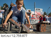 Мальчик строит дома из облицовочной гранитной плитки во время митинга обманутых дольщиков строительной компании СУ-155 на Суворовской площади города Москвы, Россия, 26 сентября 2015. Редакционное фото, фотограф Николай Винокуров / Фотобанк Лори