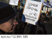 Участник митинга против расширения зоны платной парковки в спальные районы города Москвы держит плакат с надписью - "Руки прочь от спальных районов!" (2015 год). Редакционное фото, фотограф Николай Винокуров / Фотобанк Лори