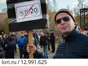 Автовладелец держит плакат на митинге против введения зоны платных парковок в городе Москве в парке спального района (2015 год). Редакционное фото, фотограф Николай Винокуров / Фотобанк Лори