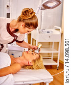 Young woman receiving electric facial massage. Стоковое фото, фотограф Gennadiy Poznyakov / Фотобанк Лори
