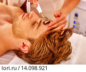 Young man receiving electric facial massage. Стоковое фото, фотограф Gennadiy Poznyakov / Фотобанк Лори