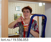 Пожилая женщина подкрашивает дверные проемы (2015 год). Редакционное фото, фотограф Вячеслав Палес / Фотобанк Лори