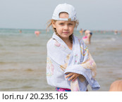 Трехлетняя девочка стоит на берегу моря укутавшись в полотенце. Стоковое фото, фотограф Иванов Алексей / Фотобанк Лори