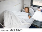 Уставшая молодая девушка спит в вагоне поезда. Стоковое фото, фотограф Иванов Алексей / Фотобанк Лори