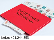 Красная зачетная книжка с банкнотами на белом фоне. Стоковое фото, фотограф Игорь Низов / Фотобанк Лори