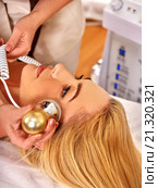 Young woman receiving electric facial massage. Стоковое фото, фотограф Gennadiy Poznyakov / Фотобанк Лори