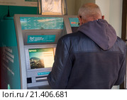 Человек стоит у банкомата банка РНКБ, Крым (2015 год). Редакционное фото, фотограф Вячеслав Палес / Фотобанк Лори