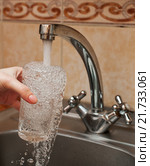 Стеклянный бокал в руке под струей холодной воды из кухонного крана. Стоковое фото, фотограф Игорь Низов / Фотобанк Лори