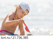 Девочка играет с песком и лопаткой на пляже моря. Стоковое фото, фотограф Иванов Алексей / Фотобанк Лори