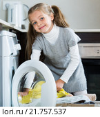 Little girl unloading washing machine and smiling. Стоковое фото, фотограф Яков Филимонов / Фотобанк Лори