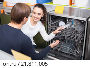 young couple choosing new dish washing machine in appliance store. Стоковое фото, фотограф Яков Филимонов / Фотобанк Лори