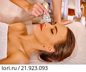 Young woman receiving electric facial massage. Стоковое фото, фотограф Gennadiy Poznyakov / Фотобанк Лори