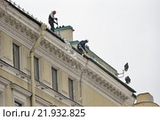 Рабочие -высотники сбрасывают снег с крыши здания на Невском Проспекте в Санкт-Петербурге 2016-02-25. Редакционное фото, фотограф Максим Мицун / Фотобанк Лори