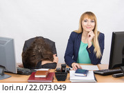 Ситуация в офисе - расстроенная девушка легла на стол, ее коллега радостно смотрит в кадр. Стоковое фото, фотограф Иванов Алексей / Фотобанк Лори