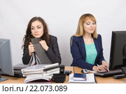 Девушки коллеги в офисе, одна устало смотрит в экран монитора, вторая счастливая работает в компьютере. Стоковое фото, фотограф Иванов Алексей / Фотобанк Лори