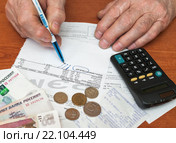 Подорожание коммуналки. Взрослый мужчина обводит итоговую сумму в квитанции на оплату коммунальных услугх (2016 год). Редакционное фото, фотограф Игорь Низов / Фотобанк Лори