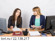 Две сотрудницы офиса сидят за рабочим столом и неприязненно смотрят друг на друга. Стоковое фото, фотограф Иванов Алексей / Фотобанк Лори