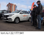 Люди изучают проспекты автомобиля Lada Xray на улицах города (2016 год). Редакционное фото, фотограф Вячеслав Палес / Фотобанк Лори