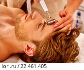 Young man receiving electric facial massage. Стоковое фото, фотограф Gennadiy Poznyakov / Фотобанк Лори