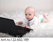 Смешной увлеченный ребенок в галстуке с компьютером. Стоковое фото, фотограф Элина Гаревская / Фотобанк Лори