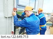 builders worker installing glass windows on facade. Стоковое фото, фотограф Дмитрий Калиновский / Фотобанк Лори