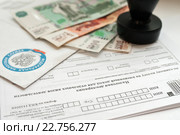 Оплата налогов. Конверт из налоговой службы, незаполненная налоговая декларация, деньги и печать предпринимателя. Стоковое фото, фотограф Игорь Низов / Фотобанк Лори