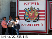 Плакат с гербом города и надписью "Керчь - город-герой" на центральной улице Кирова в городе Керчи, Республика Крым (2016 год). Редакционное фото, фотограф Николай Винокуров / Фотобанк Лори
