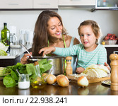 Woman with baby cooking at kitchen. Стоковое фото, фотограф Яков Филимонов / Фотобанк Лори