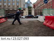 Рабочий прокладывает кабельную канализацию на Тверской улице города Москвы рядом со зданием мэрии города Москвы, Россия (2016 год). Редакционное фото, фотограф Николай Винокуров / Фотобанк Лори
