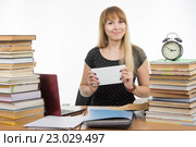Девушка приготовила конверт со взяткой преподавателю за успешный сданный экзамен. Стоковое фото, фотограф Иванов Алексей / Фотобанк Лори