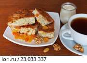 Домашний манный пирог с изюмом, яблоком и маком на столе с чашкой чая и баночкой кефира на полдник. Стоковое фото, фотограф Виктория Катьянова / Фотобанк Лори
