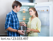 Frustraited starving female and man near fridge without any food. Стоковое фото, фотограф Яков Филимонов / Фотобанк Лори