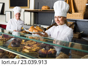 Agreeable woman and young girl reccomending pastry. Стоковое фото, фотограф Яков Филимонов / Фотобанк Лори