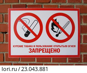 Табличка "Курение табака и пользование открытым огнем запрещено" на фоне кирпичной стены. Стоковое фото, фотограф Ирина Краснова / Фотобанк Лори