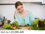Young housewife tired of cooking vegetables in domestic kitchen. Стоковое фото, фотограф Яков Филимонов / Фотобанк Лори