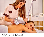 Young woman receiving electric back massage. Стоковое фото, фотограф Gennadiy Poznyakov / Фотобанк Лори