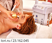 Young man receiving electric facial massage. Стоковое фото, фотограф Gennadiy Poznyakov / Фотобанк Лори