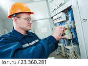 electrician with screwdriver repair switching electric actuator in fuse box. Стоковое фото, фотограф Дмитрий Калиновский / Фотобанк Лори