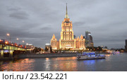 Туристический кораблик проплывает на фоне гостиницы "Рэдиссон Ройал, Москва" ("Украина") в вечерних сумерках. Вечерняя Москва (2016 год). Редакционное видео, видеограф Виктор Карасев / Фотобанк Лори