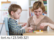 Child boy playing with education toys at the table in kindergarten. Стоковое фото, фотограф Оксана Кузьмина / Фотобанк Лори