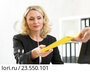 middle-aged businesswoman giving paper to colleague. Стоковое фото, фотограф Оксана Кузьмина / Фотобанк Лори